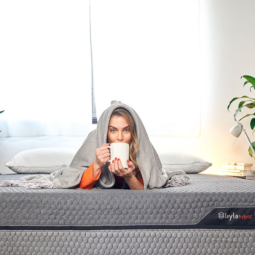 Women have a cup of coffee on Layla Hybrid Mattress