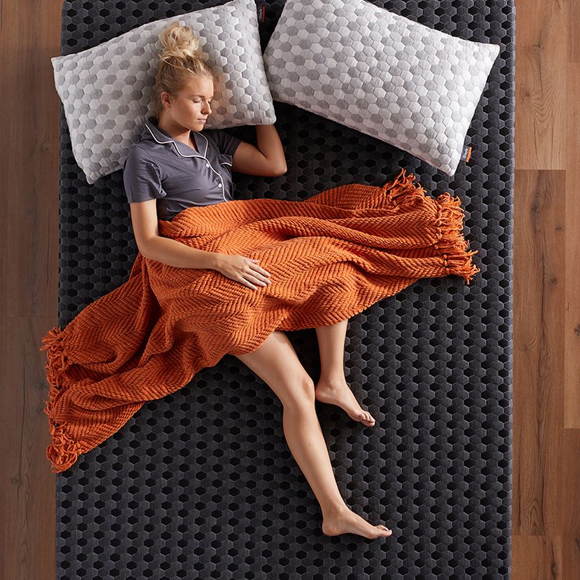 Girl with orange blanket lying on Memory Foam Mattress