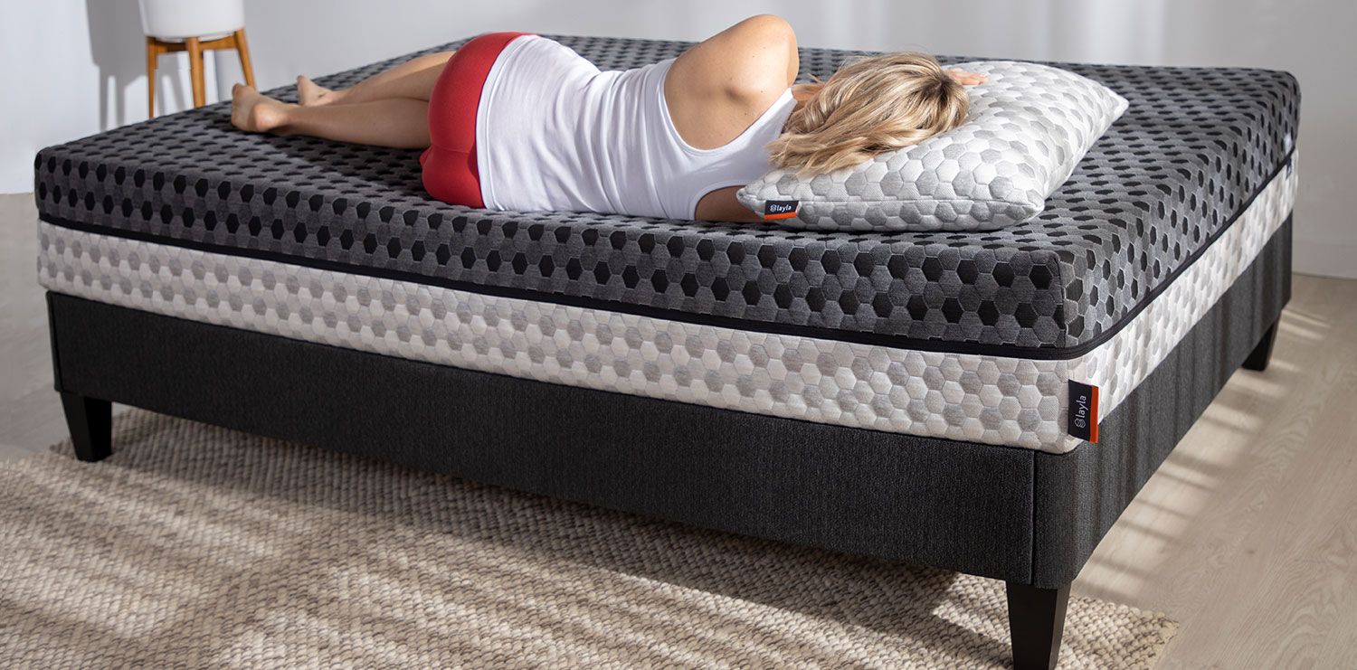 Woman is lying on mattress.