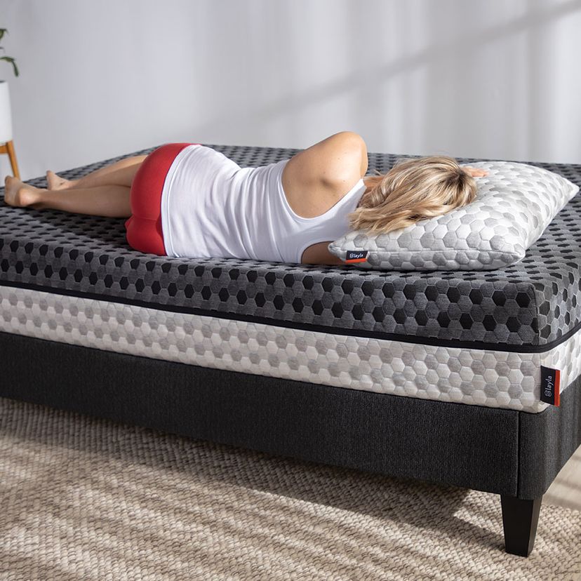 Woman is lying on mattress.