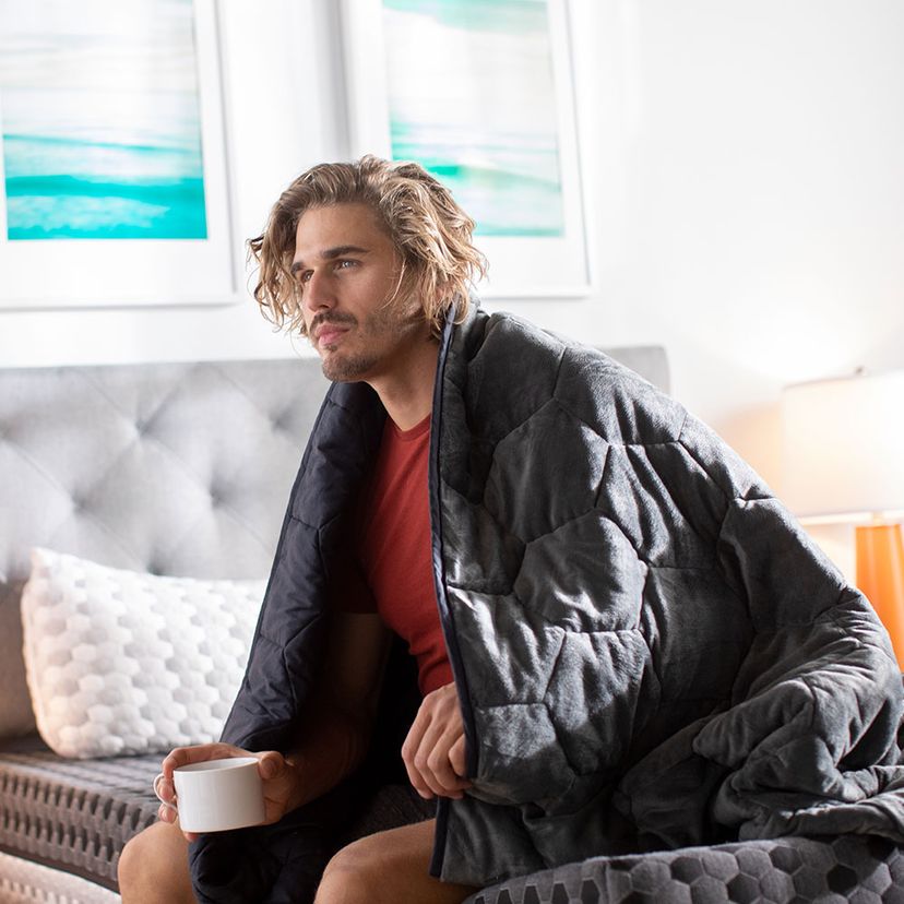 man covered with weighted blanket